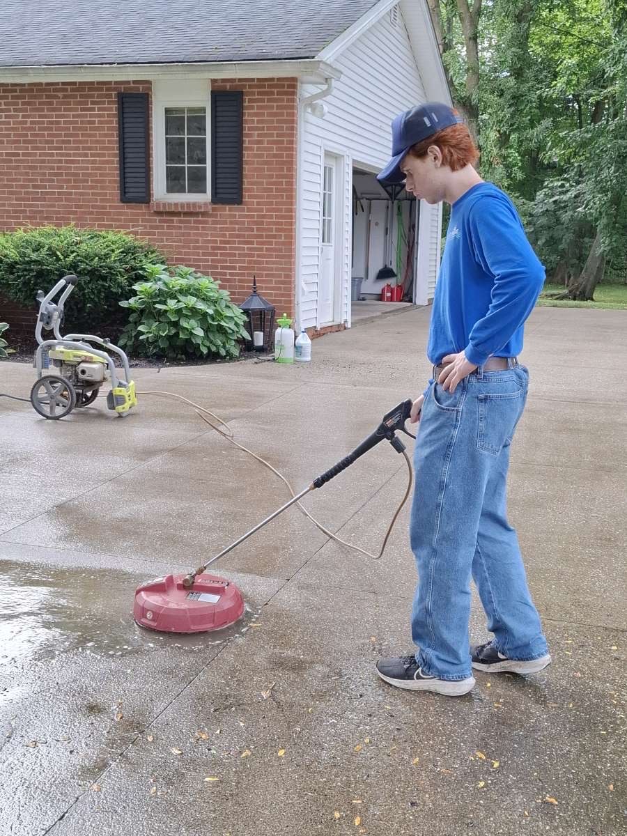 Lake Side Wash surface cleaning a concrete driveway beside a brick house
